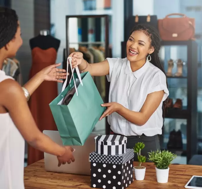 Lady in retail taking payment of goods with a card machine